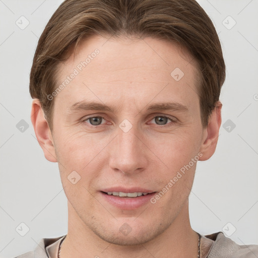 Joyful white young-adult male with short  brown hair and grey eyes