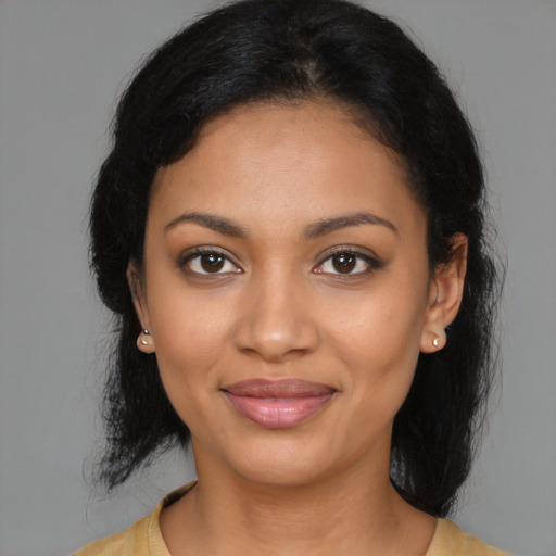 Joyful black young-adult female with long  black hair and brown eyes