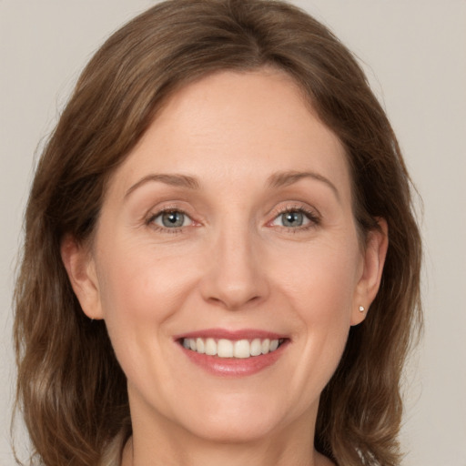 Joyful white adult female with medium  brown hair and grey eyes