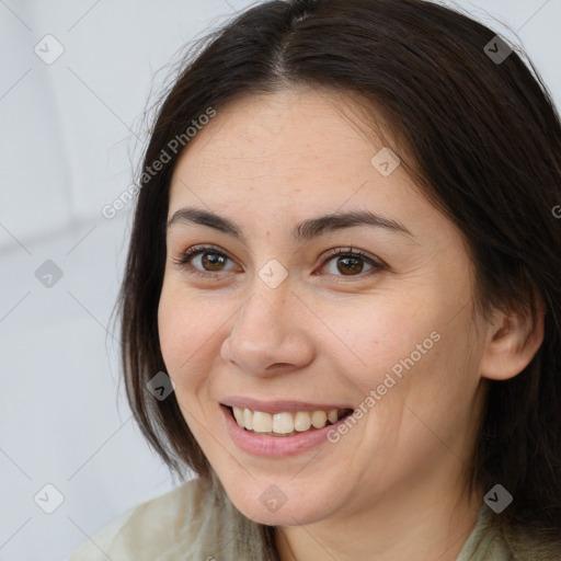 Joyful white young-adult female with long  brown hair and brown eyes