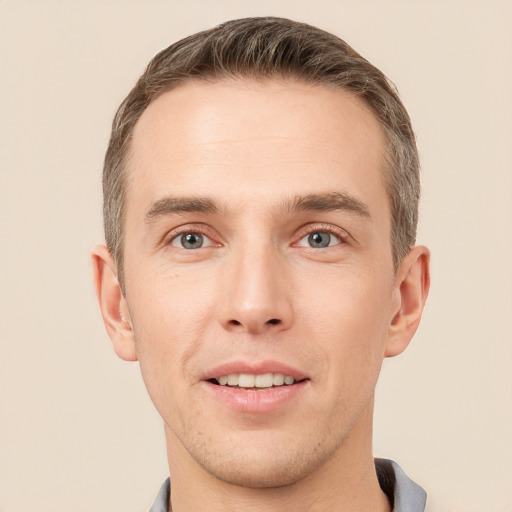 Joyful white young-adult male with short  brown hair and grey eyes