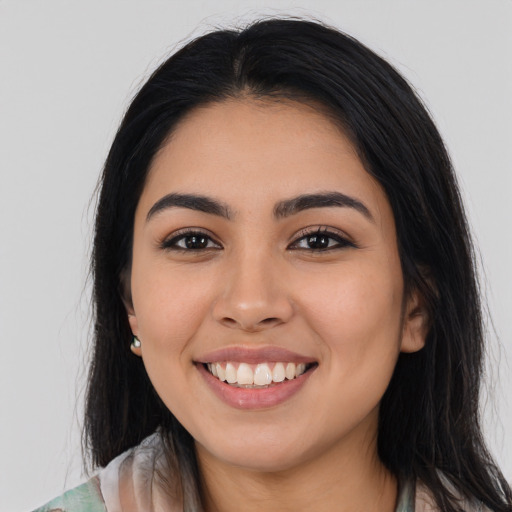 Joyful latino young-adult female with long  black hair and brown eyes