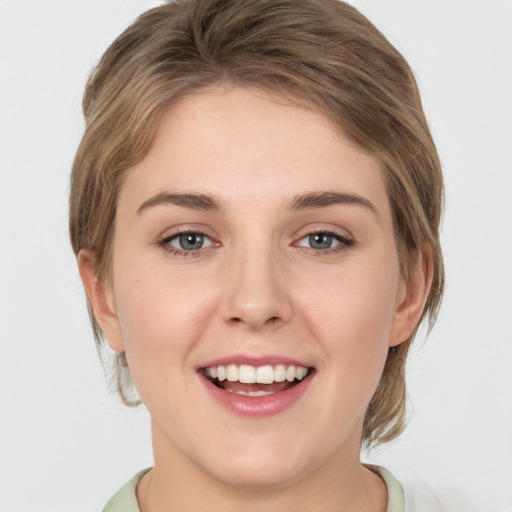 Joyful white young-adult female with medium  brown hair and green eyes