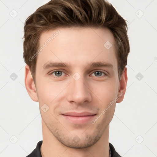 Joyful white young-adult male with short  brown hair and grey eyes