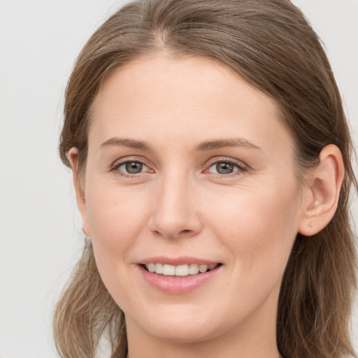 Joyful white young-adult female with long  brown hair and grey eyes