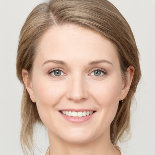 Joyful white young-adult female with medium  brown hair and grey eyes