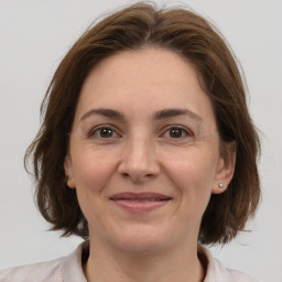 Joyful white adult female with medium  brown hair and brown eyes