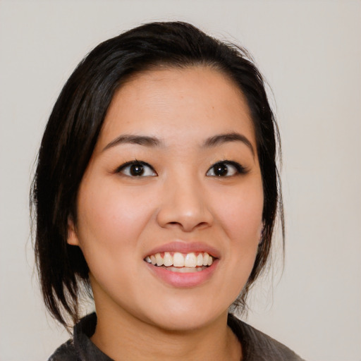 Joyful asian young-adult female with medium  black hair and brown eyes