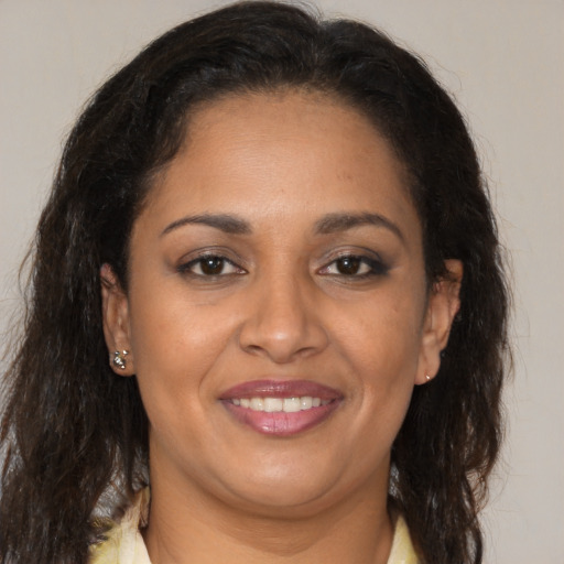 Joyful latino adult female with medium  brown hair and brown eyes