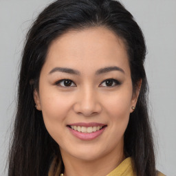 Joyful latino young-adult female with long  brown hair and brown eyes