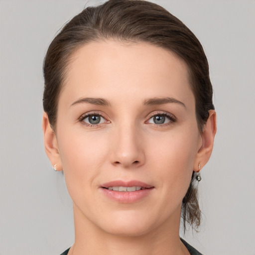 Joyful white young-adult female with medium  brown hair and grey eyes