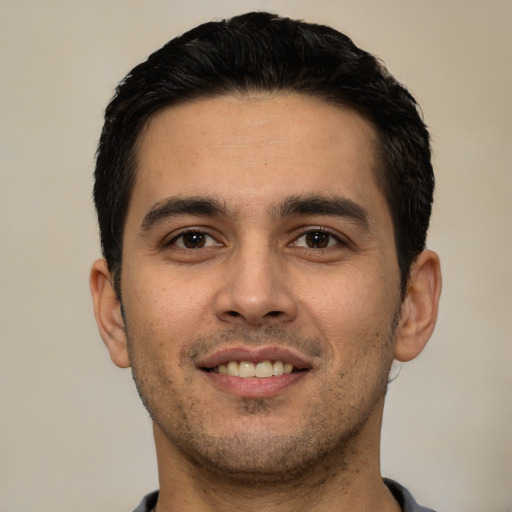 Joyful white young-adult male with short  black hair and brown eyes