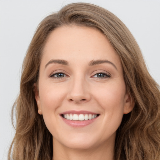 Joyful white young-adult female with long  brown hair and grey eyes