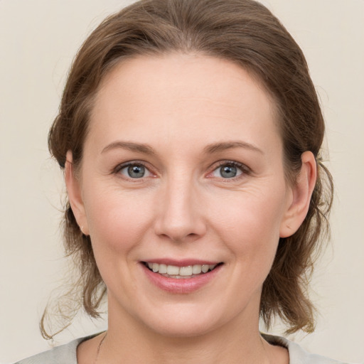 Joyful white young-adult female with medium  brown hair and grey eyes