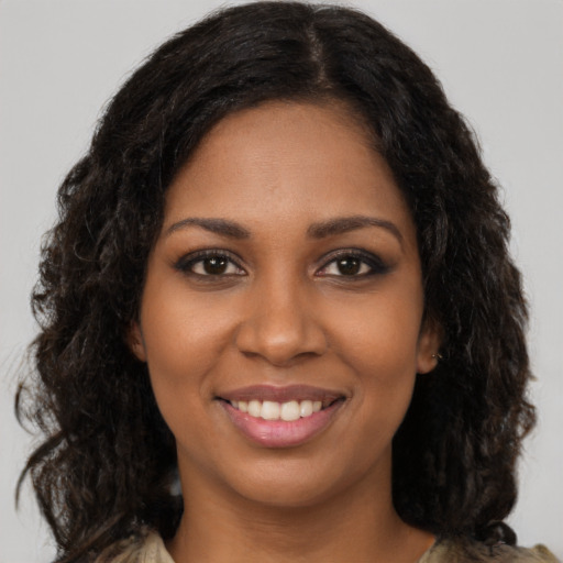Joyful black young-adult female with long  black hair and brown eyes