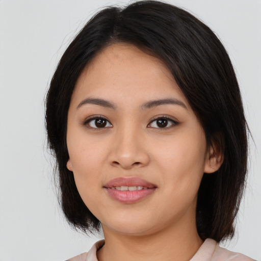 Joyful asian young-adult female with medium  brown hair and brown eyes
