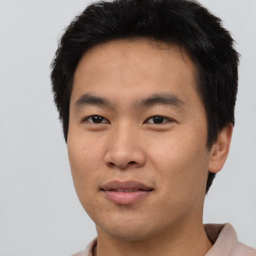 Joyful asian young-adult male with short  black hair and brown eyes