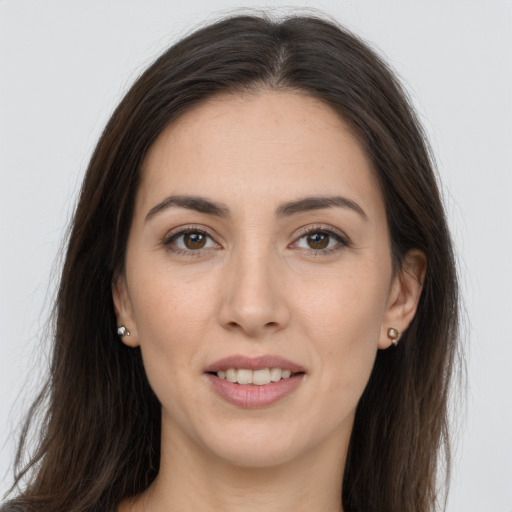 Joyful white young-adult female with long  brown hair and brown eyes