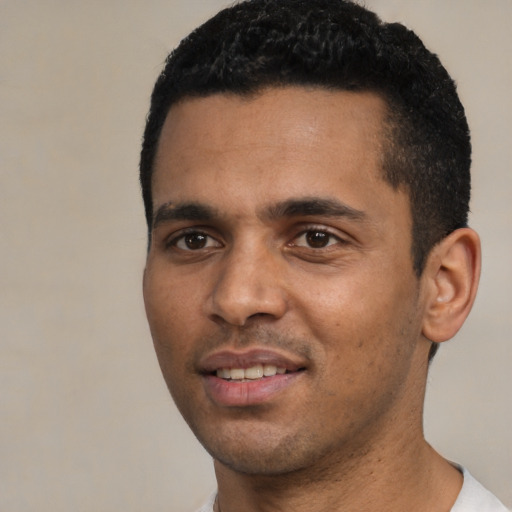Joyful black young-adult male with short  black hair and brown eyes