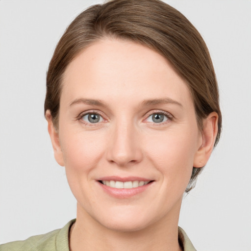 Joyful white young-adult female with short  brown hair and grey eyes