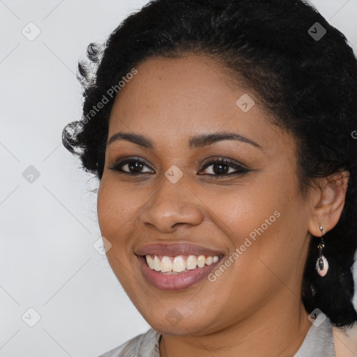 Joyful black young-adult female with long  black hair and brown eyes