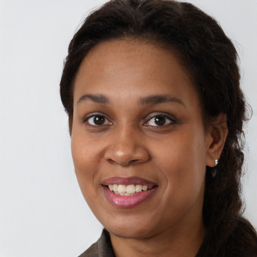 Joyful black young-adult female with long  brown hair and brown eyes