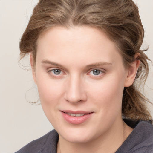 Joyful white young-adult female with medium  brown hair and blue eyes