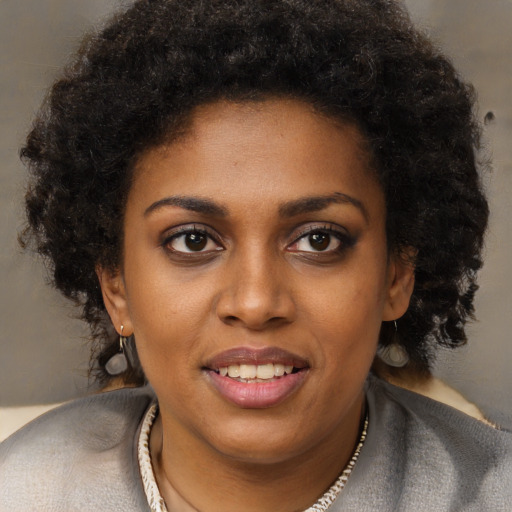 Joyful black young-adult female with long  brown hair and brown eyes