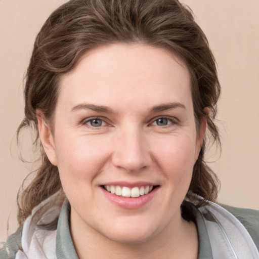 Joyful white young-adult female with medium  brown hair and grey eyes