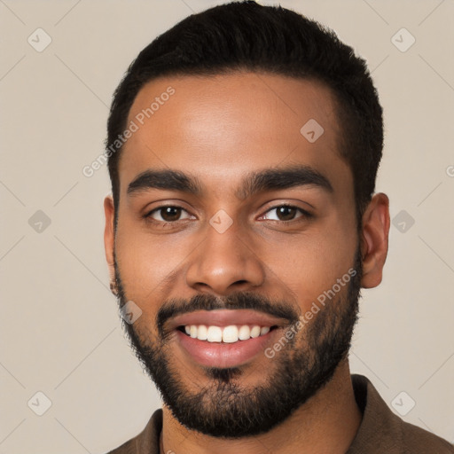 Joyful black young-adult male with short  black hair and brown eyes