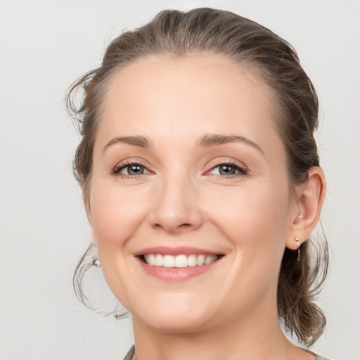 Joyful white young-adult female with medium  brown hair and grey eyes