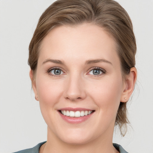 Joyful white young-adult female with medium  brown hair and grey eyes