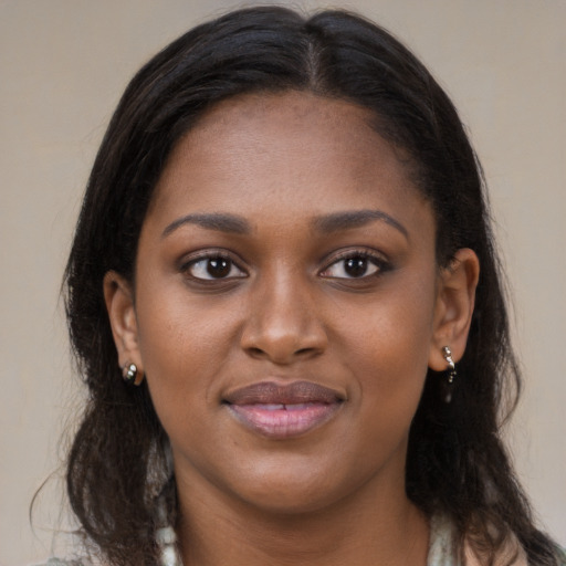 Joyful black young-adult female with long  brown hair and brown eyes