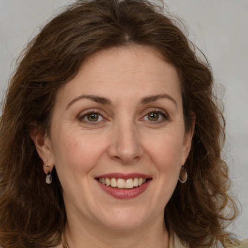 Joyful white adult female with long  brown hair and grey eyes