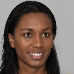 Joyful black young-adult female with long  brown hair and brown eyes