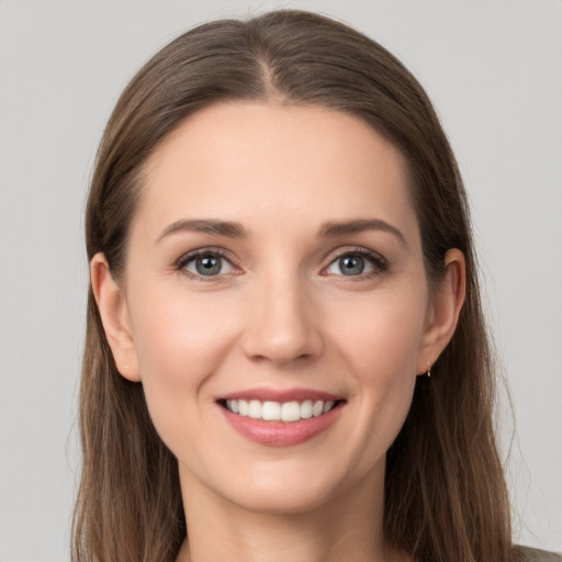 Joyful white young-adult female with long  brown hair and grey eyes