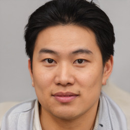 Joyful asian young-adult male with short  brown hair and brown eyes