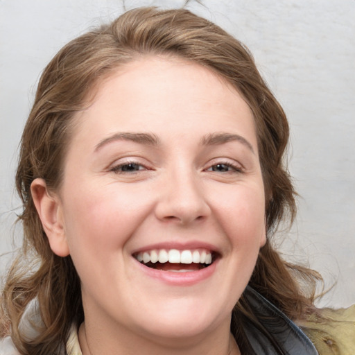 Joyful white young-adult female with medium  brown hair and blue eyes