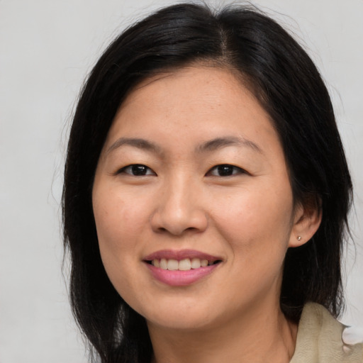 Joyful asian young-adult female with long  brown hair and brown eyes