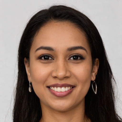 Joyful latino young-adult female with long  brown hair and brown eyes