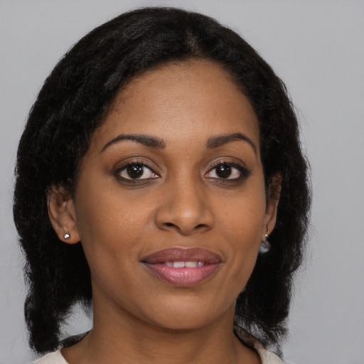Joyful black young-adult female with medium  black hair and brown eyes