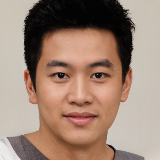 Joyful asian young-adult male with short  brown hair and brown eyes