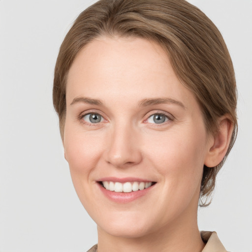 Joyful white young-adult female with medium  brown hair and grey eyes