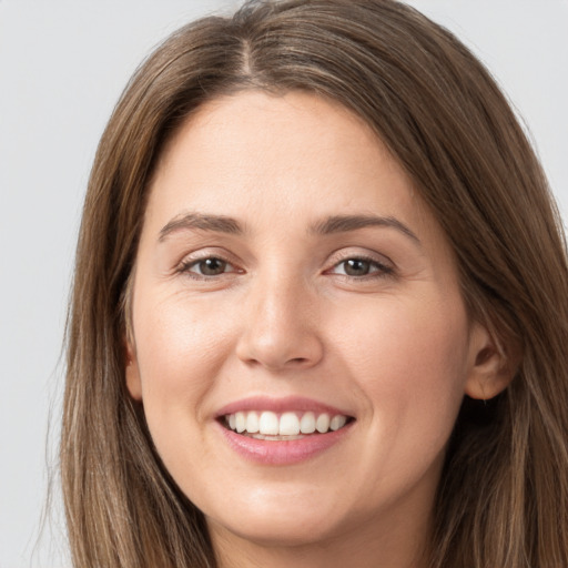 Joyful white young-adult female with long  brown hair and grey eyes