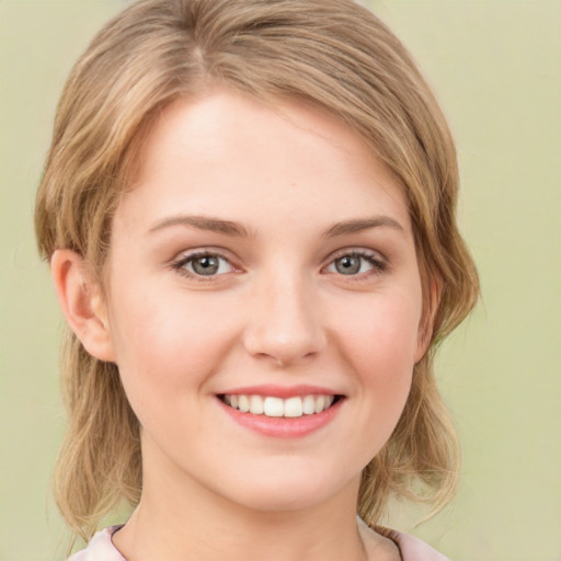 Joyful white young-adult female with medium  brown hair and green eyes