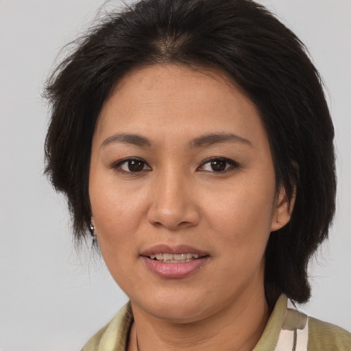 Joyful latino adult female with medium  brown hair and brown eyes