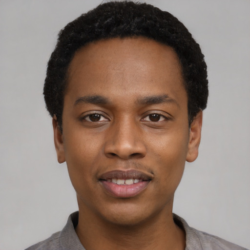 Joyful black young-adult male with short  black hair and brown eyes