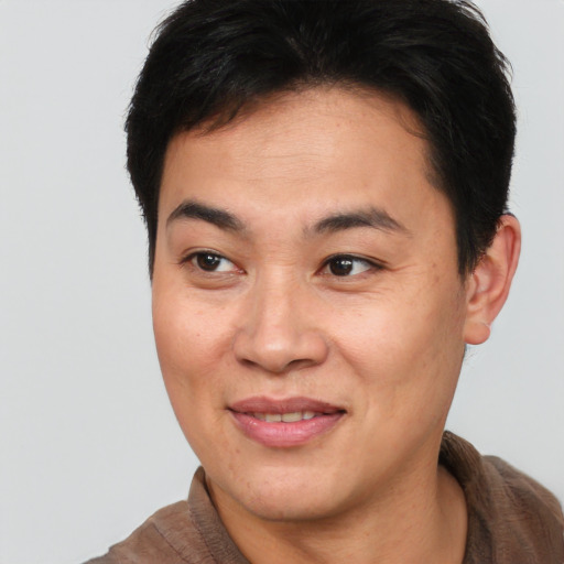Joyful asian young-adult male with short  brown hair and brown eyes