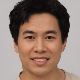 Joyful asian young-adult male with short  black hair and brown eyes