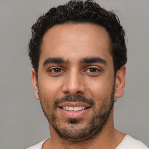 Joyful white young-adult male with short  black hair and brown eyes